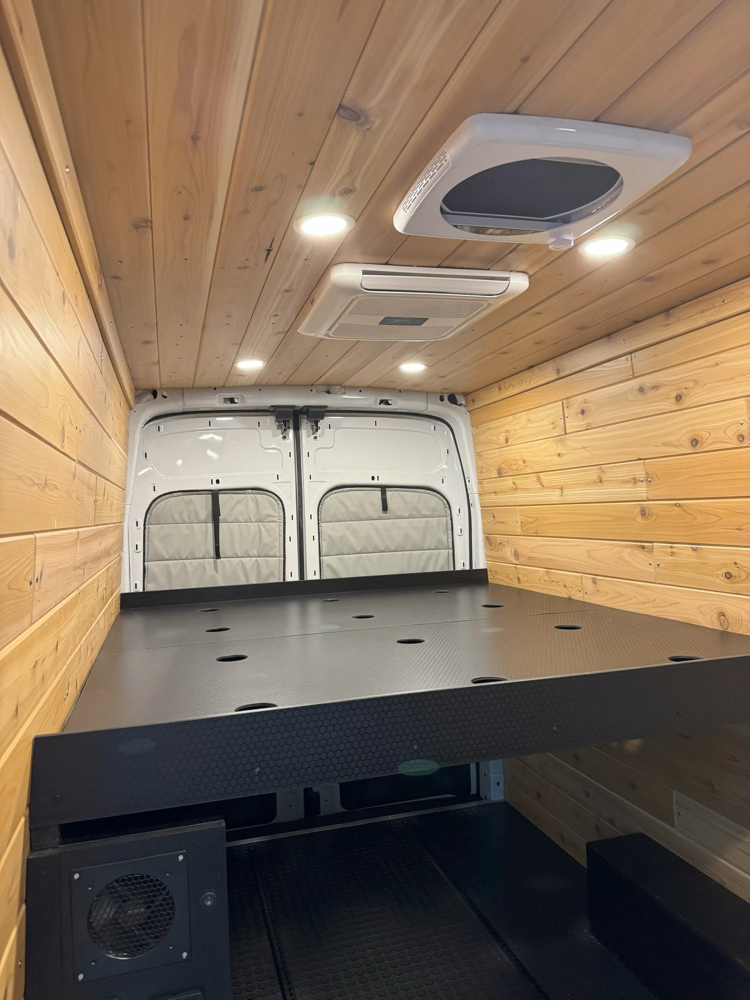 Cedar Minimal's finished cedar-lined interior and black queen bed platform