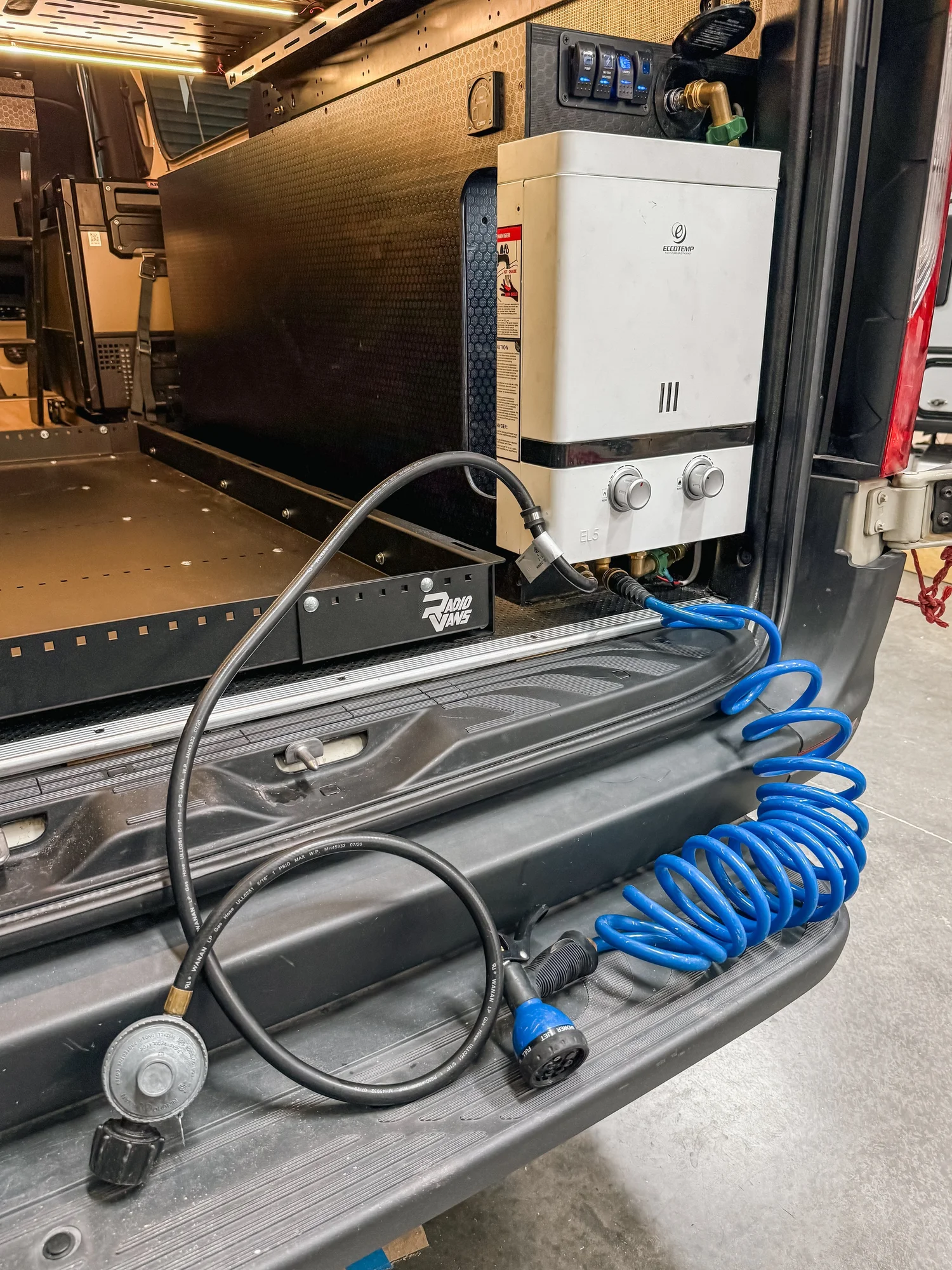 A hose and water-system access at the rear of the Sprinter.
