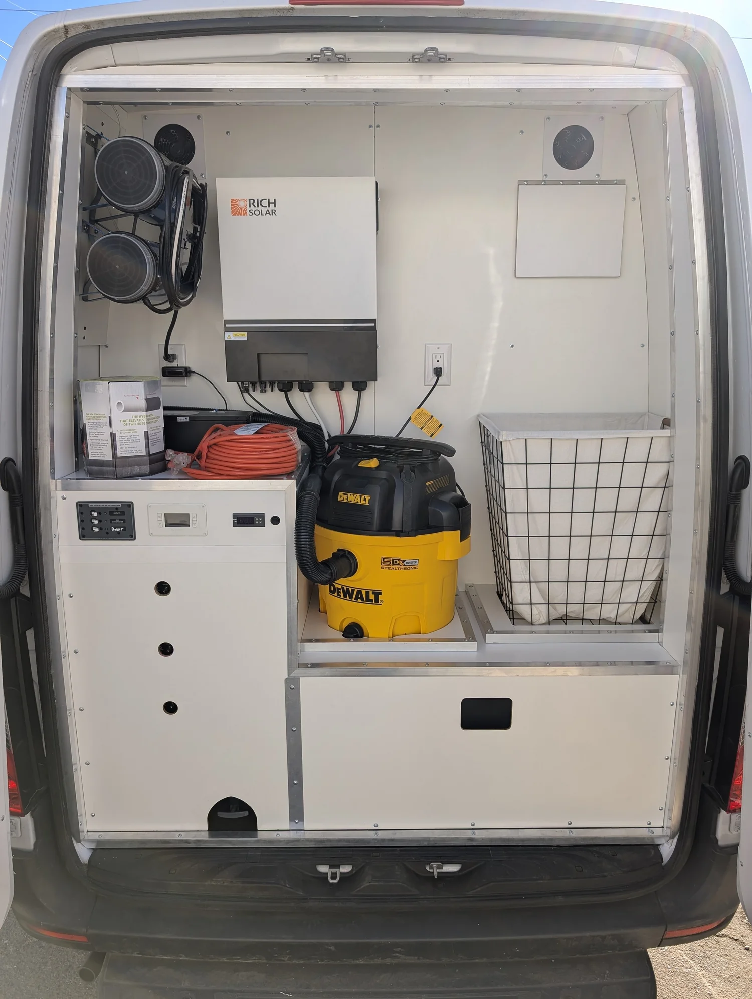 Finished mobile grooming work area with stainless tub, electric table, storage, and washable surfaces